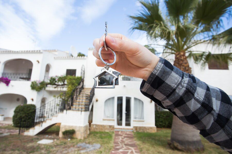 holding-house-keys-house-shaped-keychain-front-new-home_230311-5153.jpg