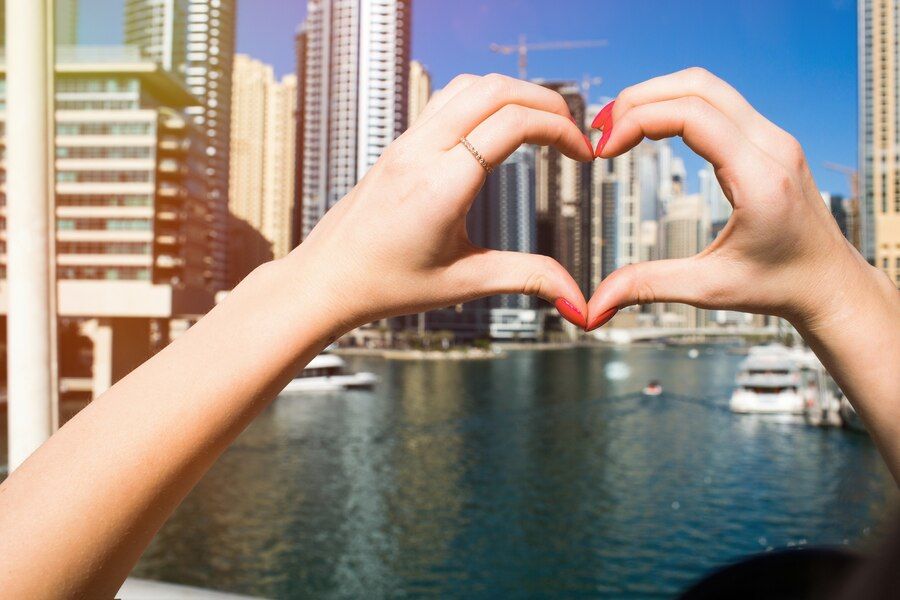 lady-with-red-nails-shows-heart-with-her-fingers-before-skyscrapers-dubai_1304-3031.jpg