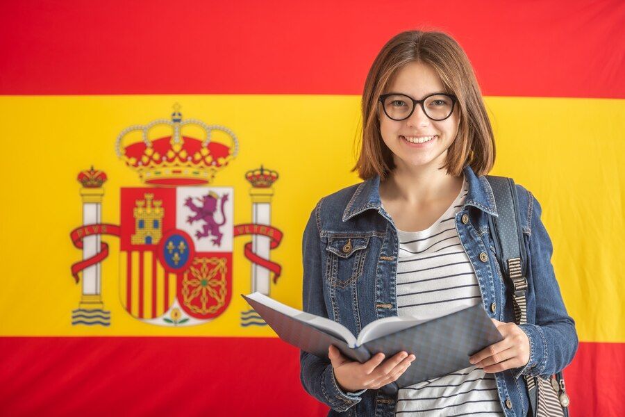 young-female-student-glasses-hold-open-textbook-front-flag-spain_341862-676.jpg