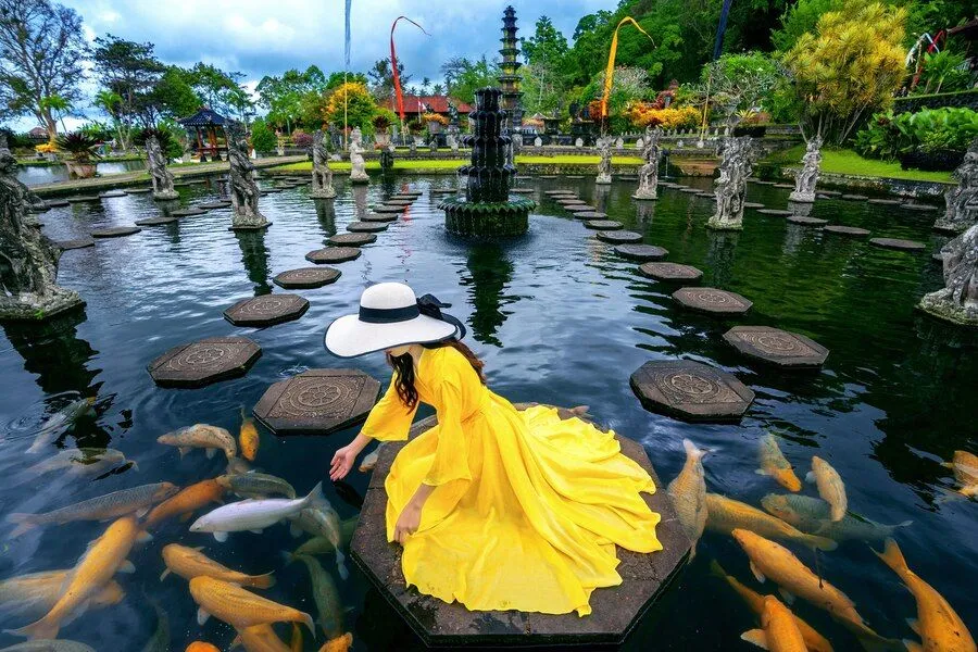 woman-feeding-colorful-fish-pond-tirta-gangga-water-palace-bali-indonesia_335224-360.jpg